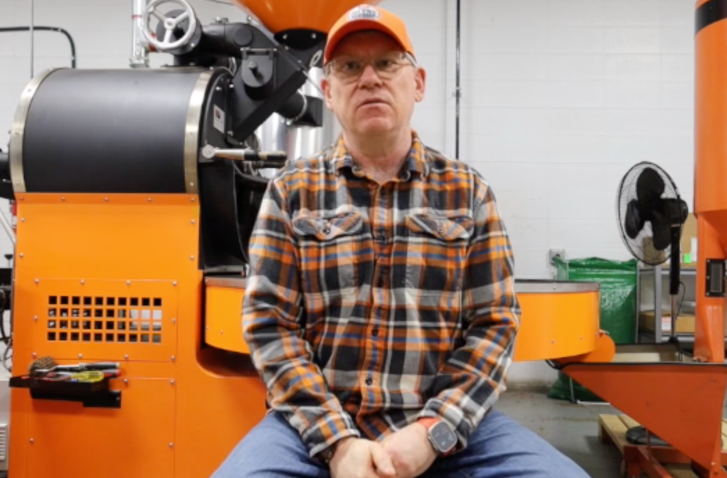 Poul Mark sitting in front of coffee roaster