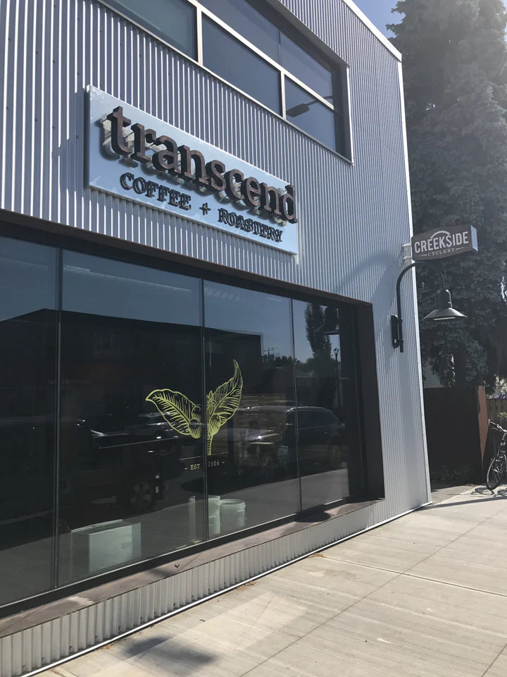 Modern building exterior with 'Transcend Coffee + Roastery' sign